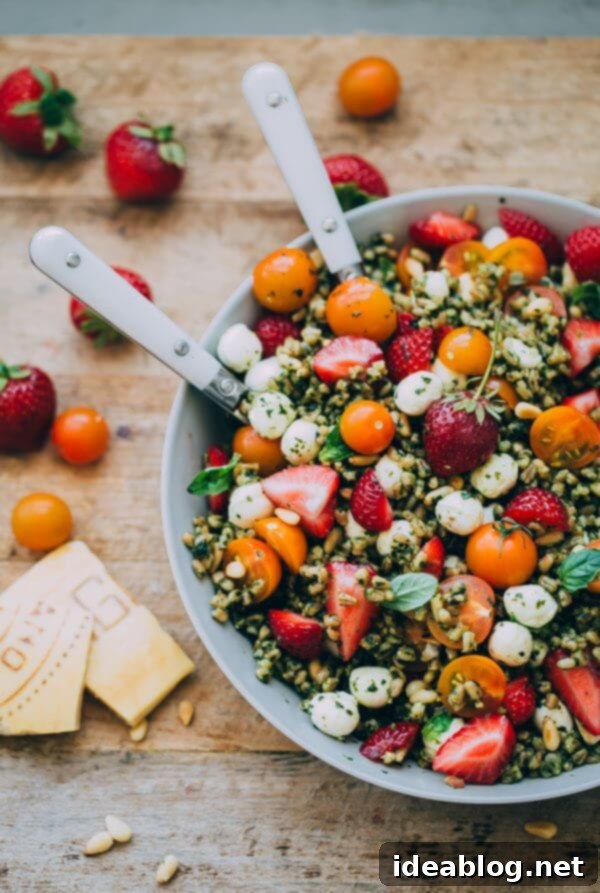 Strawberry Caprese Farro Salad. Hearty farro is tossed with homemade pesto, strawberries, tomatoes, and mozzarella cheese to create this beautiful summer grain salad! #salad #abeautifulplate #recipe #farro #caprese #mozzarella Strawberry Caprese Farro Salad