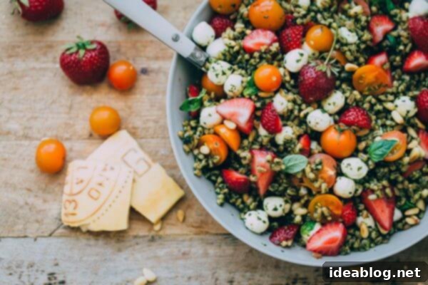 Strawberry Caprese Farro Salad. Hearty farro is tossed with homemade pesto, strawberries, tomatoes, and mozzarella cheese to create this beautiful summer grain salad! #salad #abeautifulplate #recipe #farro #caprese #mozzarella Strawberry Caprese Farro Salad