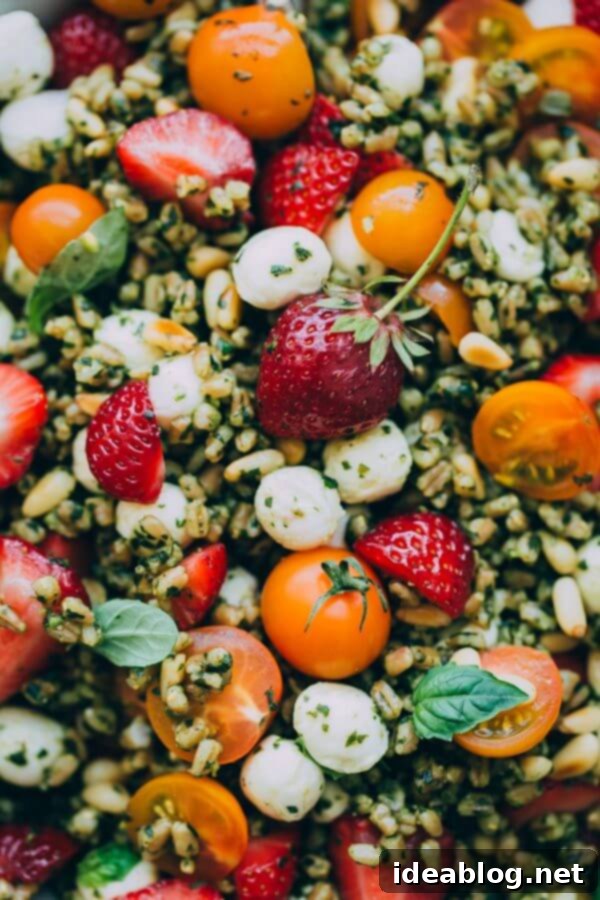 Strawberry Caprese Farro Salad. Hearty farro is tossed with homemade pesto, strawberries, tomatoes, and mozzarella cheese to create this beautiful summer grain salad! #salad #abeautifulplate #recipe #farro #caprese #mozzarella Strawberry Caprese Farro Salad
