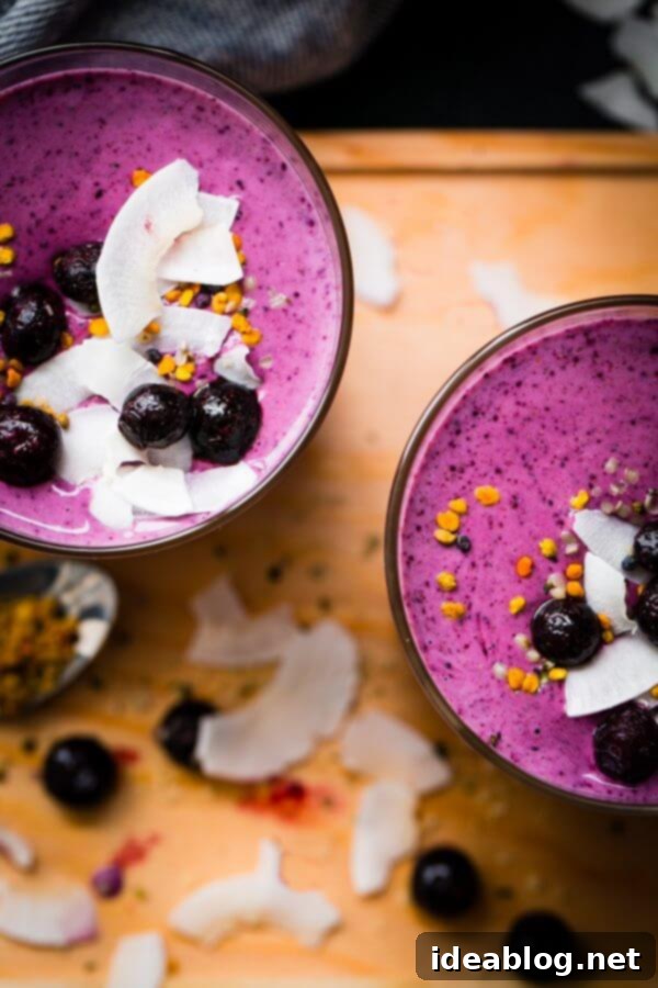 Simple Berry Smoothie - made with greek yogurt, frozen berries, coconut water, and my favorite smoothie addition: almond buttter.  Vibrant Berry Smoothie - closeup of a healthy smoothie made with frozen blueberries, Greek yogurt, coconut water, banana, and almond butter.