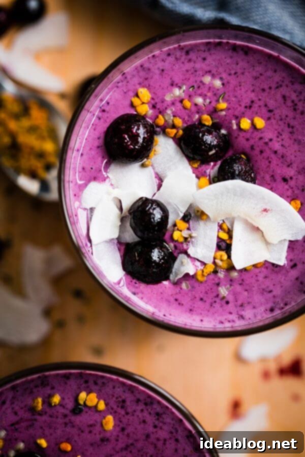 Simple Berry Smoothie - made with greek yogurt, frozen berries, coconut water, and my favorite smoothie addition: almond buttter.  Simple Berry Smoothie - a healthy, vibrant smoothie made with frozen blueberries, Greek yogurt, coconut water, banana, and almond butter, in a clear glass.