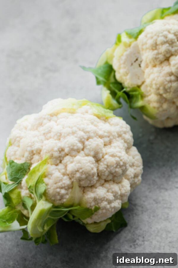 Velvety Roasted Cauliflower Soup: Coconut Turmeric Delight 2 Whole head of fresh cauliflower on a cutting board