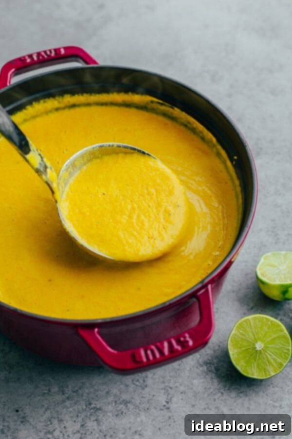 Creamy Cauliflower Soup in a Pot Roasted Cauliflower Soup with Coconut and Turmeric simmering in a pot