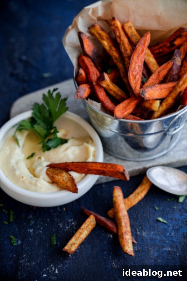 Golden Spiced Sweet Potato Fries with Creamy Garlic Aioli 3 Perfectly Crispy Baked Sweet Potato Fries with a side of creamy Homemade Garlic Aioli, garnished with fresh herbs, ideal for a comforting fall snack or appetizer.