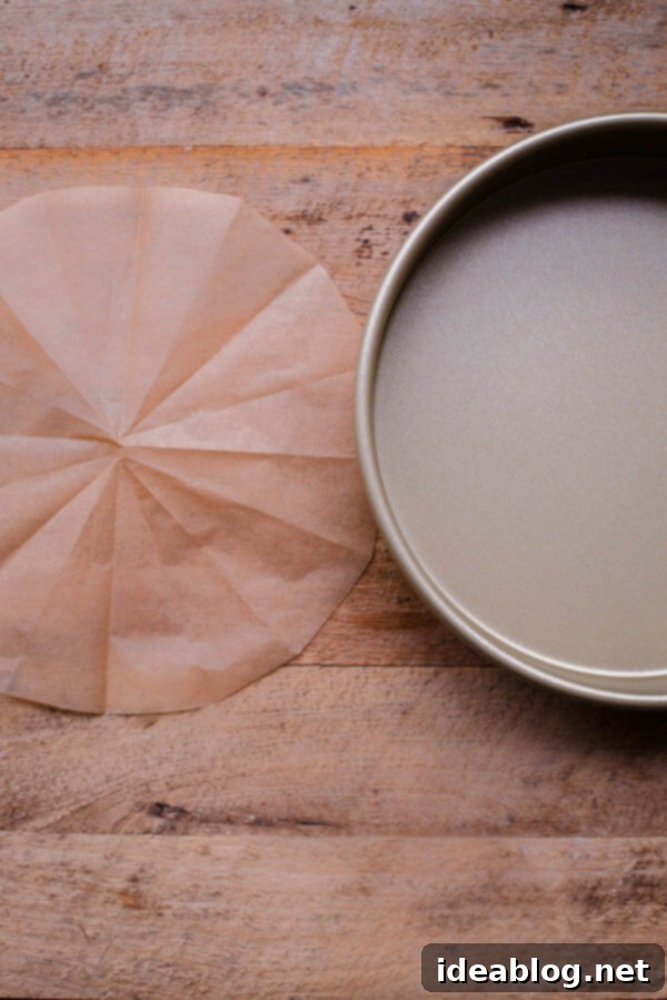 Flawless Cake Release: Parchment Lining Any Pan 12 The perfectly cut parchment paper round is unfolded, showcasing its precise circular shape for the cake pan.