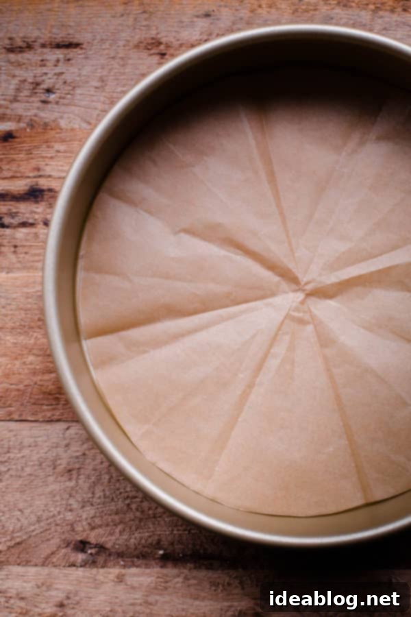 Flawless Cake Release: Parchment Lining Any Pan 13 The custom-cut parchment paper fits perfectly inside the cake pan, ready for greasing and batter.