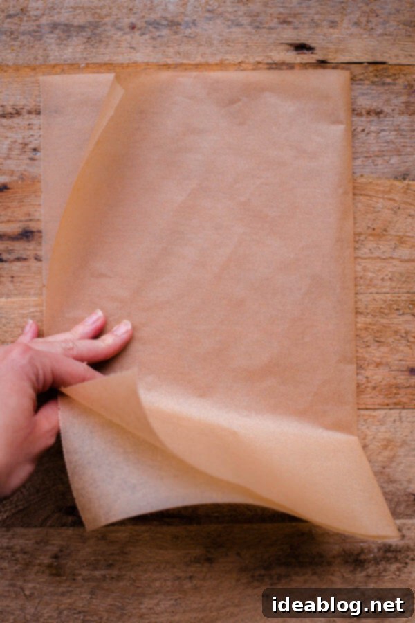 Flawless Cake Release: Parchment Lining Any Pan 5 Second fold: The half-folded parchment paper is folded again, quartering the paper into a compact square.