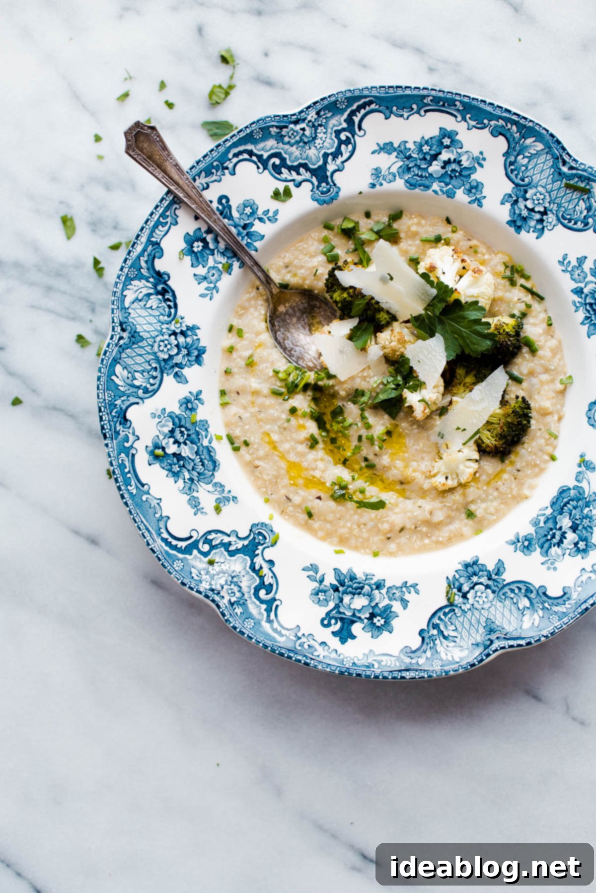 A close-up of the delicious dairy-free quinoa risotto, showcasing the creamy texture achieved with white bean puree and topped with fresh herbs. Dairy-Free Quinoa Risotto with White Beans