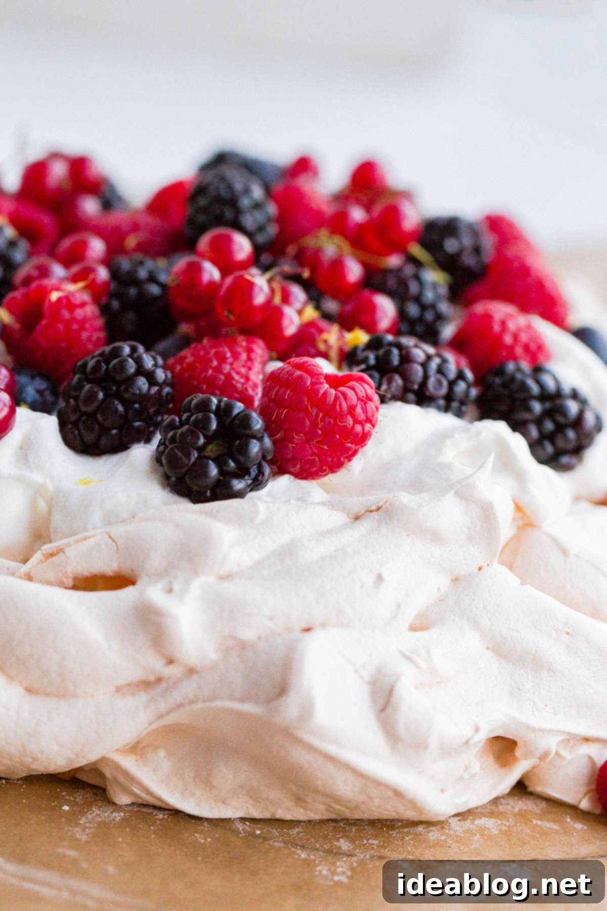 An inviting easy lemon berry pavlova, perfect for a refreshing dessert, filled with creamy lemon and fresh berries. A slice of Easy Lemon Berry Pavlova showcasing the crisp meringue, creamy lemon filling, and mixed berries