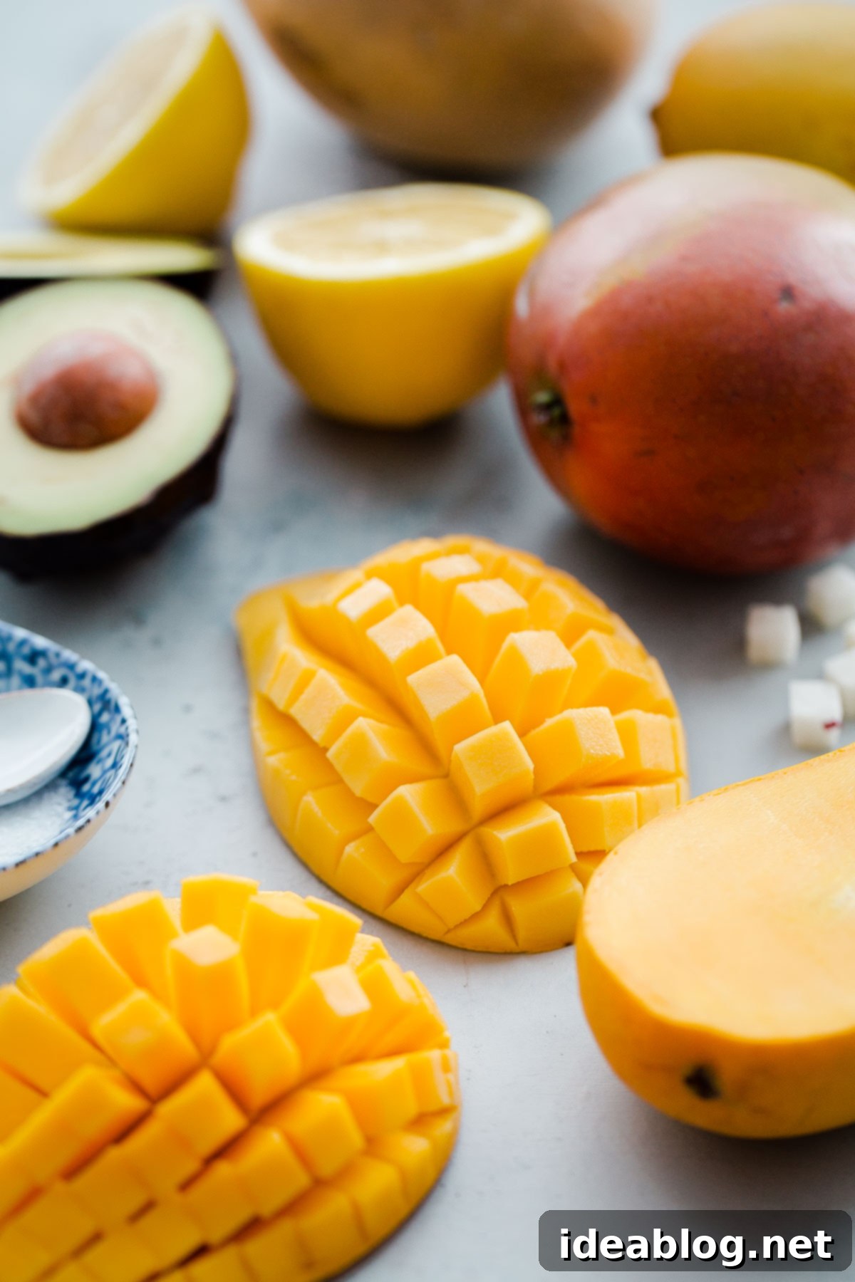 Perfectly cut mangos, diced into small, uniform cubes, demonstrating the ideal preparation for integrating into a creamy, chunky guacamole. Expertly sliced ripe mangos showcasing their vibrant color and succulent flesh, ready for dicing into the tropical guacamole.