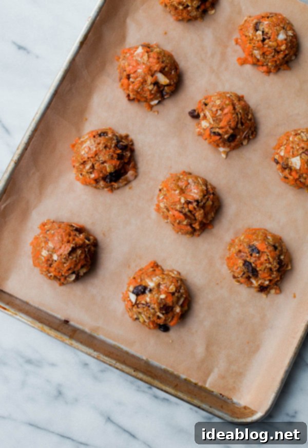 Carrot Cake Breakfast Cookies - healthy breakfast cookies that are refined sugar free, whole grain, and taste just like carrot cake! #abeautifulplate #ecipe #breakfast #breakfastcookies #oatmeal #carrotcake Carrot Cake Breakfast Cookies baking on a sheet pan