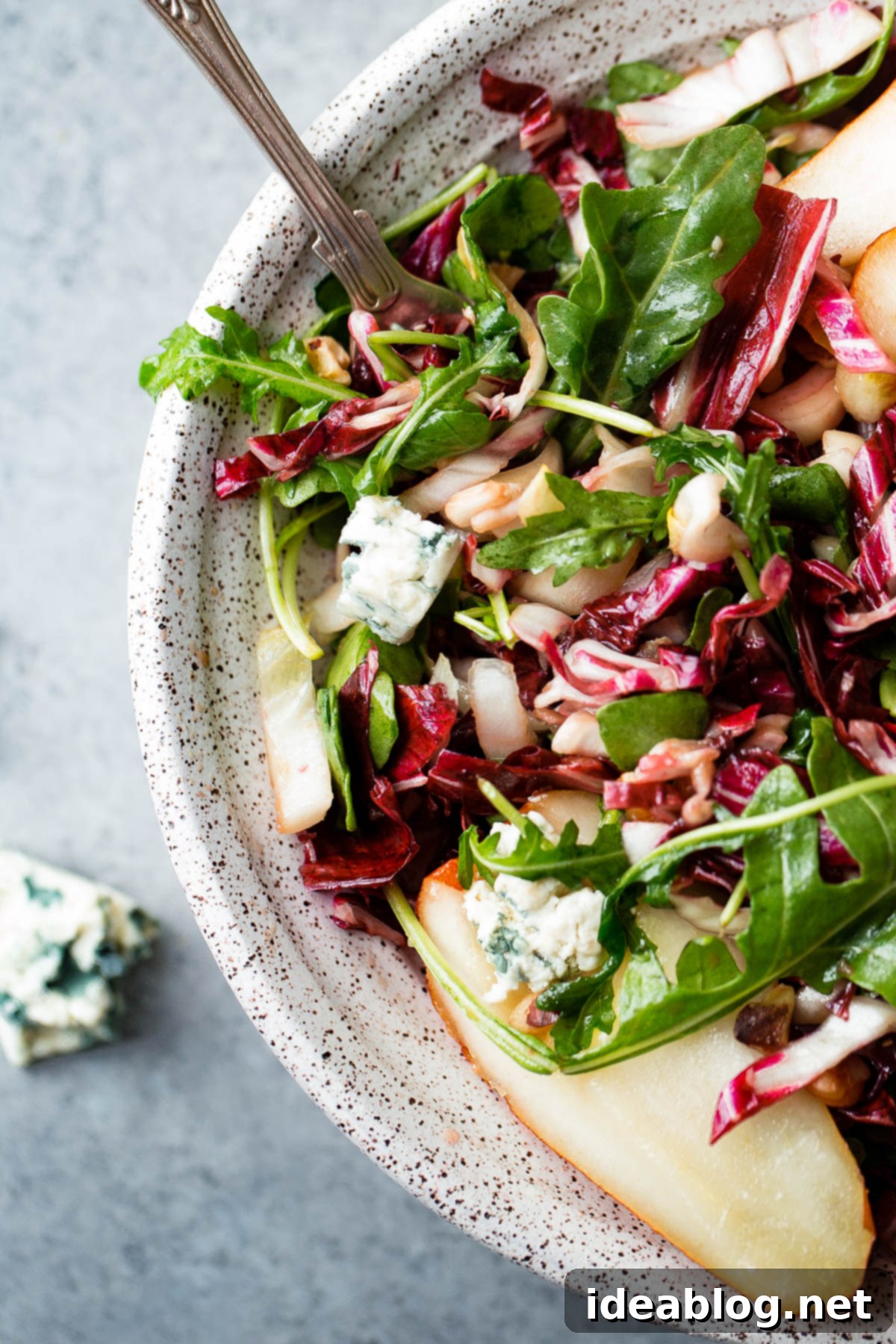 Detailed view of Fall Harvest Salad components, highlighting the fresh and crisp textures. Close-up of Fall Harvest Salad ingredients: radicchio, endive, pear, walnuts