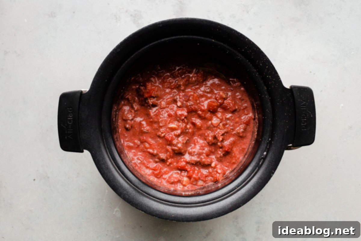 Deep-Flavor Bolognese Ragu 11 A ladle full of slow cooker bolognese sauce ready to be served over pasta.