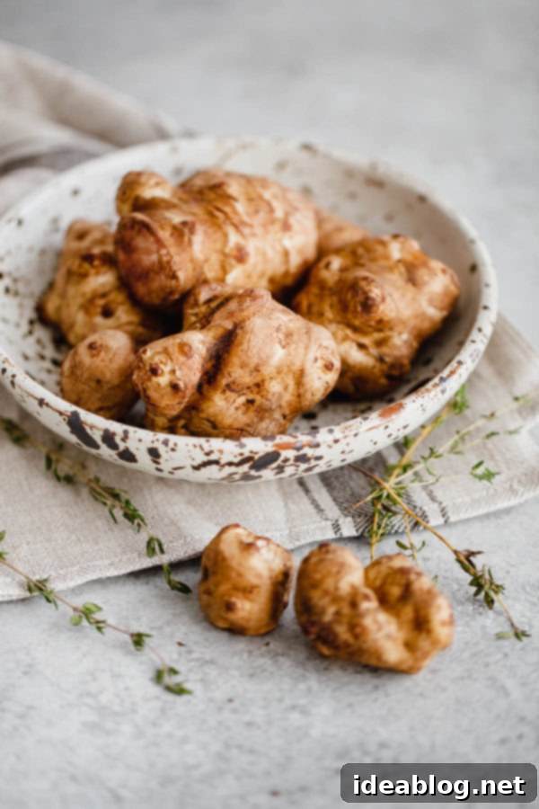 Fresh Sunchokes (Jerusalem Artichokes) for roasting, a healthy fall and winter vegetable. #sunchokes #Jerusalemartichoke #thyme #vegetable #roasted #abeautifulplate Fresh Sunchokes (Jerusalem Artichokes) in a rustic bowl before preparation