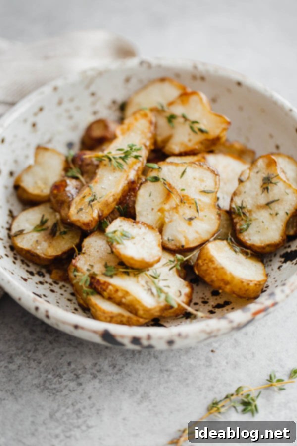 Delicious Roasted Sunchokes (Jerusalem artichokes) tossed with fresh thyme, a perfect healthy side dish. Roasted Sunchokes with a garnish of fresh herbs in a serving bowl