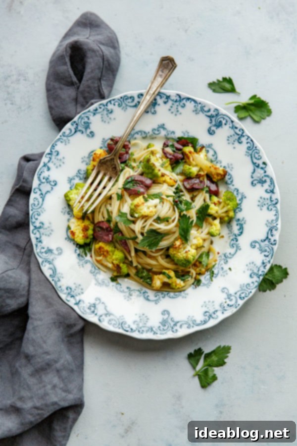 Romanesco Cauliflower Pasta with Olives, Capers, and Parsley. A simple vegetarian pasta recipe that can be made in less than 45 minutes, highlighting healthy ingredients. #pasta #recipe #romanesco #cauliflower #olive #caper #abeautifulplate A close-up of Romanesco Cauliflower Pasta with Olives, Capers, and Parsley, garnished with fresh parsley.