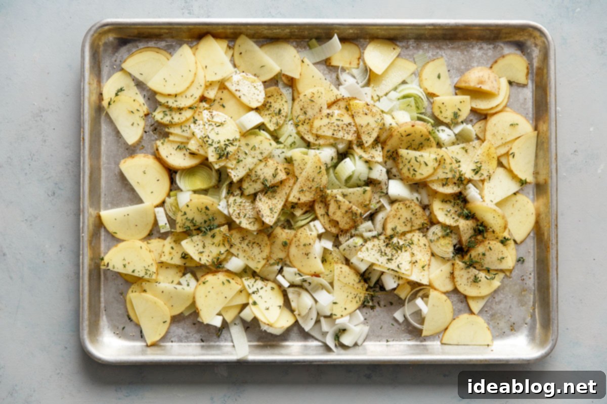 Golden Potato Leek Cornish Pasty 7 Sliced potatoes and leeks on a sheet pan, seasoned and ready for roasting
