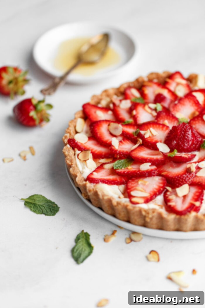 Luscious Strawberry Mascarpone Tart 2 No Bake Strawberry Tart with fresh strawberries and mint on top, sliced almonds, and a creamy mascarpone filling