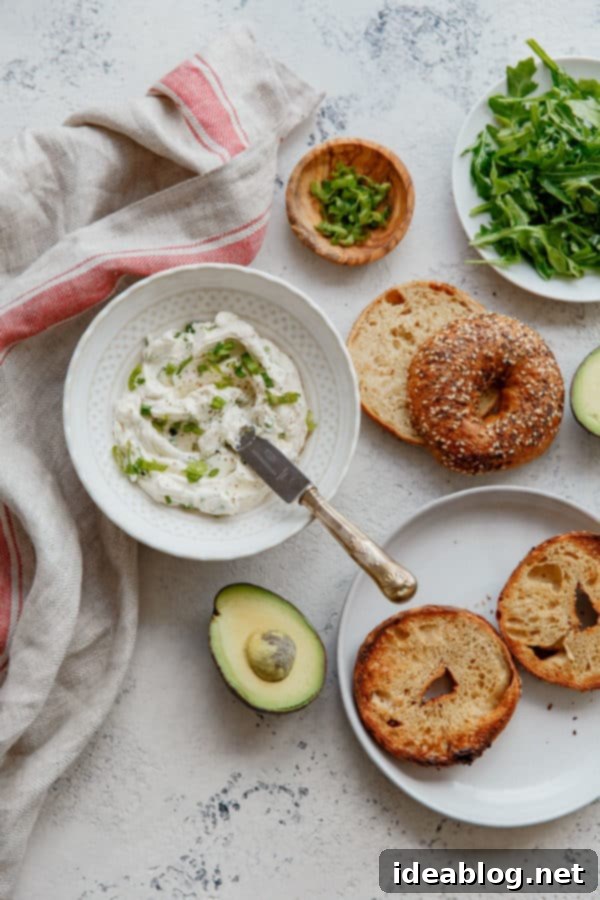 Homemade Everything Bagel Sandwich - featuring homemade scallion and black pepper cream cheese, fresh avocado, and peppery arugula on an everything bagel. The BEST easy breakfast sandwich for any day!  Delicious Everything Bagel Sandwich with avocado, scallion cream cheese, and arugula