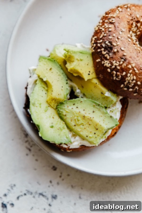 Everything Bagel Sandwich - homemade scallion and black pepper cream cheese, creamy avocado, and peppery arugula on an everything bagel. This AMAZING breakfast sandwich comes together in minutes!  Gourmet Avocado Cream Cheese Bagel Toast with everything bagel seasoning