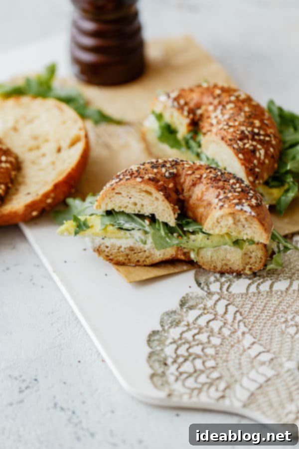 Everything Bagel Sandwich - a perfect breakfast or brunch idea with homemade scallion and black pepper cream cheese, avocado, and peppery arugula. Delicious and quick to prepare!  Fully assembled Everything Bagel Sandwich with avocado and homemade cream cheese