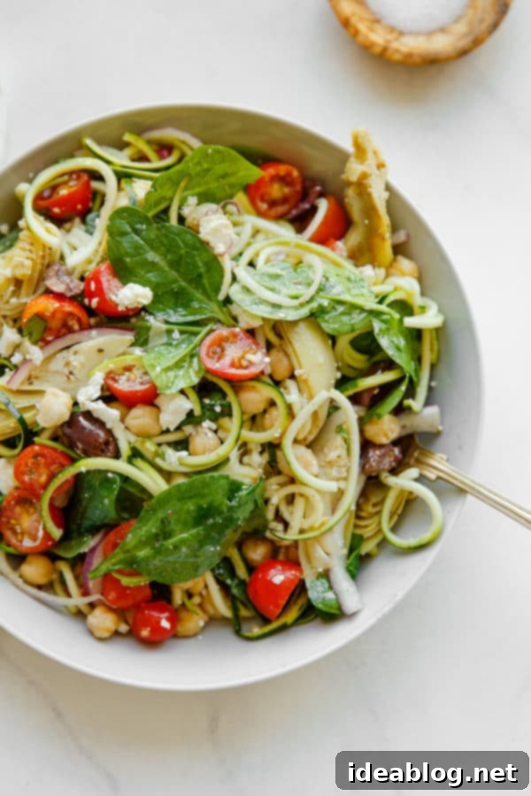 Mediterranean Zucchini Pasta Salad - this refreshing and lightened up Mediterranean Zucchini Pasta Salad is prepared with zucchini noodles in lieu of traditional pasta, and tossed with briny feta, chickpeas, artichoke hearts, tomatoes, spinach, and olives. #zucchini #vegetarian #glutenfree #abeautifulplate #healthy #Mediterranean Mediterranean Zucchini Pasta Salad