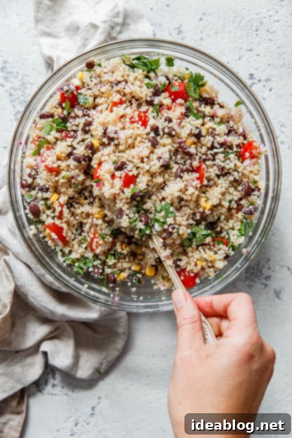 Southwest Quinoa Salad - an easy, flavorful, and vegetarian southwestern quinoa salad with black beans, tomatoes, jalapeño, red onion, cotija cheese, fire roasted corn, and a simple lime vinaigrette. #salad #quinoa #abeautifulplate #healthy #summer #recipe Close-up of Southwest Quinoa Salad, showing vibrant colors and textures of ingredients like quinoa, corn, tomatoes, and black beans