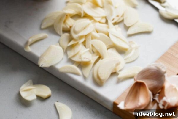 Crispy Homemade Garlic Chips 3 Thinly sliced garlic cloves, neatly arranged, highlighting their readiness for the cooking process.