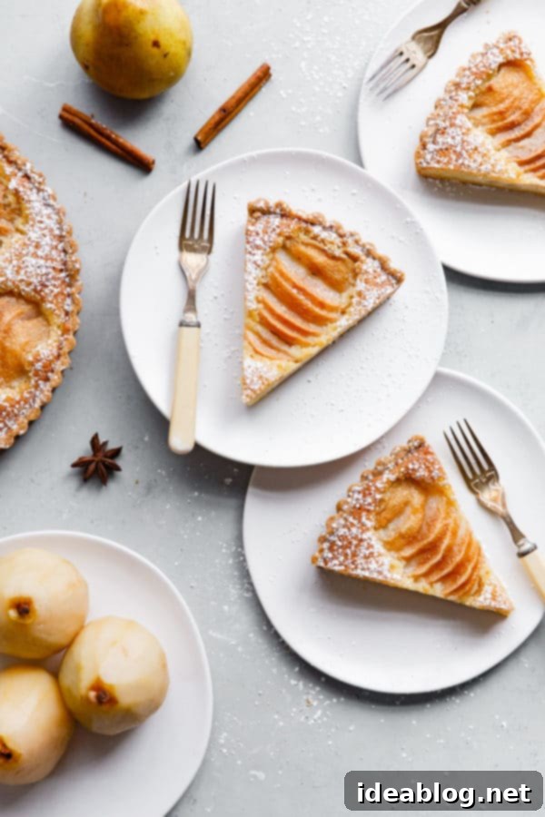 Pear Frangipane Tart - a classic French poached pear tart recipe with sweet dough, poached pears, and almond cream. Ideal for Thanksgiving or holiday season. Top with powdered sugar or apricot glaze. #tart #recipe #pear #frangipane #poached #French #dessert #pastry Slices of a perfectly baked Pear Frangipane Tart, showcasing the golden crust, creamy almond filling, and artfully arranged poached pear halves, ready to be served as a delightful French dessert for the holidays
