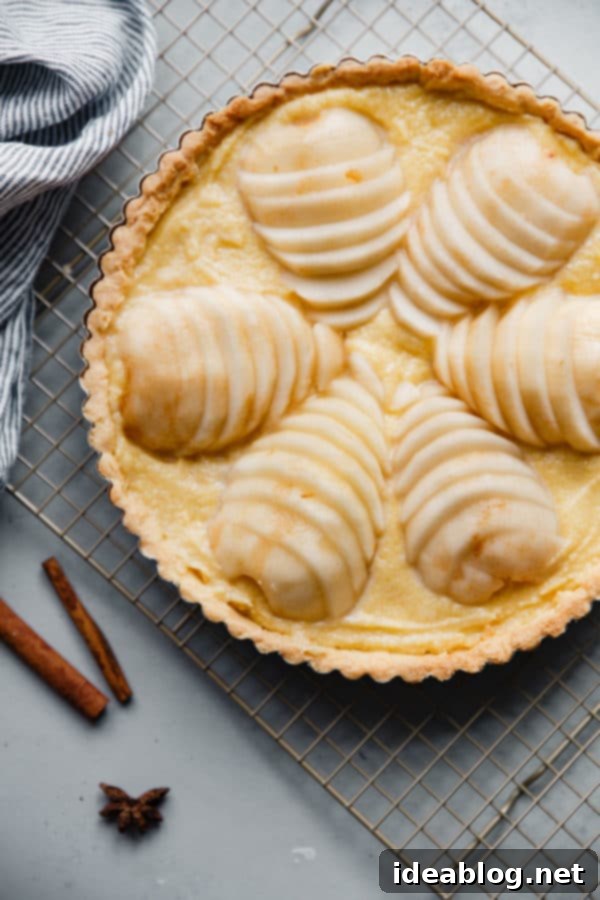 Elegant Pear & Almond Tart 8 A tart shell filled with frangipane and fanned poached pears, ready for baking, illustrating the careful assembly of this delicious French pear tart
