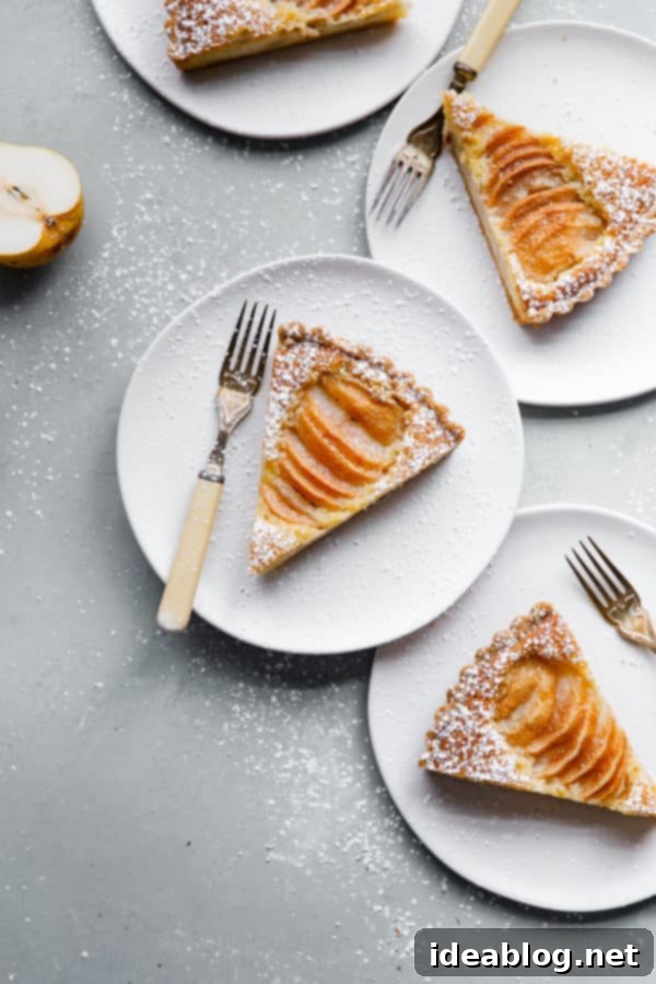 Elegant Pear & Almond Tart 6 Overhead view of a beautifully baked Pear Frangipane Tart, showcasing the fanned poached pear slices and the rich, golden frangipane beneath, ready to be enjoyed