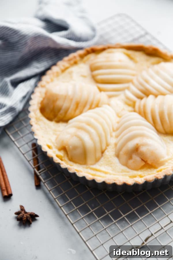 Elegant Pear & Almond Tart 7 Smooth, creamy frangipane filling being spread into a blind-baked tart crust, showcasing the rich texture before the poached pears are added for a classic French dessert