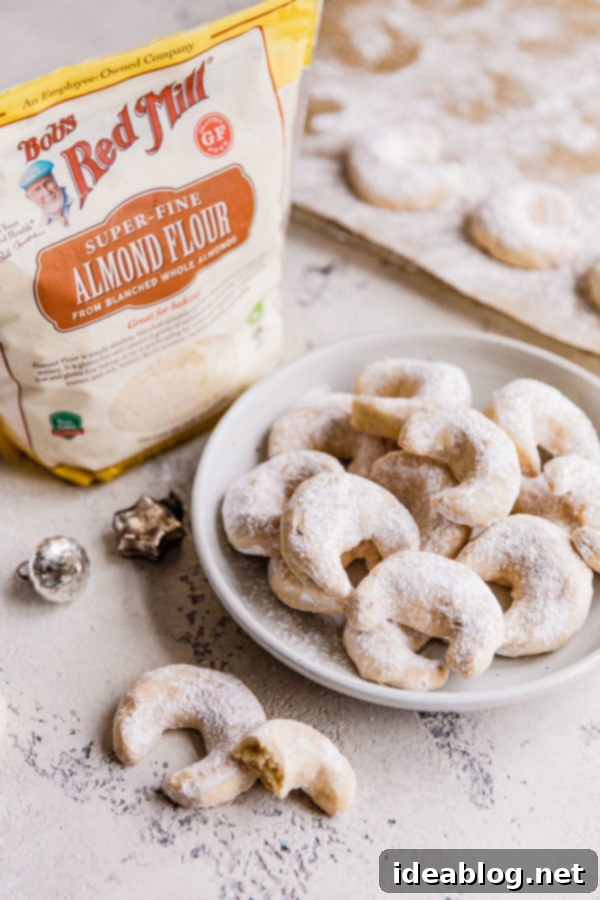 Almond Crescent Cookies - these traditional Almond Crescent Cookies (or Austrian kipferl cookies) are my go-to easy Christmas cookies. Buttery, crisp, and impossible to resist! #abeautifuplate #almondflour #kipferl #almondcrescentcookies #recipe #dessert #Christmas #holiday #baking Various baking ingredients, including a bag of Bob's Red Mill Almond Flour, alongside butter and extracts.