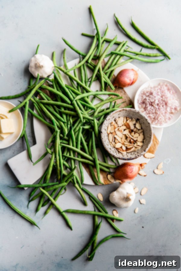 Essential Ingredients for a Delicious Green Beans Almondine Fresh Ingredients for Green Beans Almondine including shallots, garlic, lemon, and French green beans