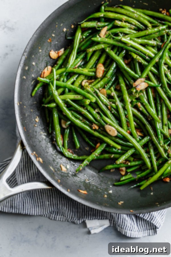 Cooking Green Beans Almondine: Sautéing in a Skillet Hands preparing Green Beans Almondine in a skillet