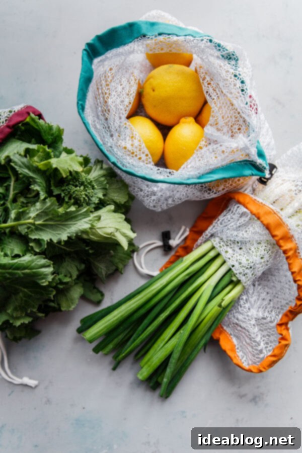 5 Easy Ways to Reduce Kitchen Waste - helpful resources, practical tools and tips, and approachable ways to reduce your kitchen waste and carbon footprint.  Fresh fruits and vegetables in reusable mesh produce bags, promoting sustainable shopping.
