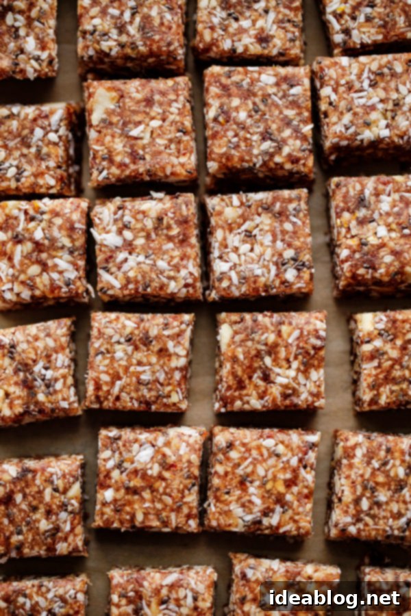 A batch of chilled no-bake energy bites, freshly sliced into perfect squares, showcasing their dense and textured interior.