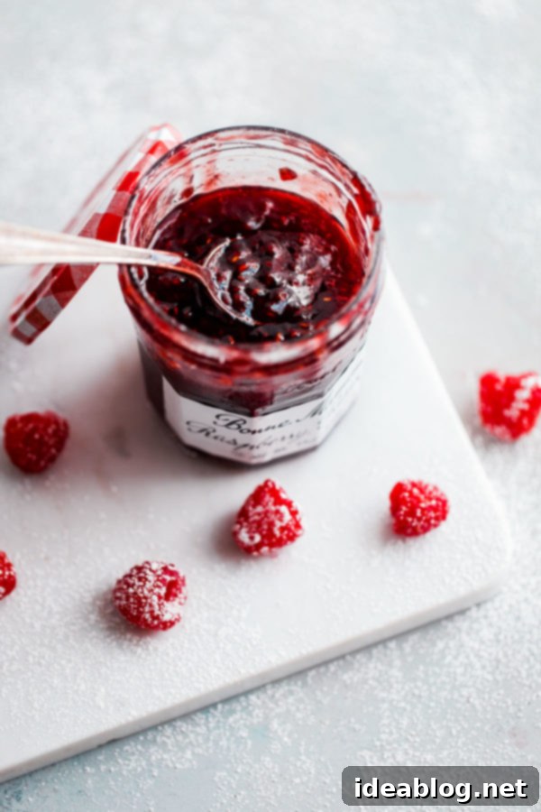 Bonne Maman Raspberry Preserves - the perfect sweet and tart filling for our matcha roll cake. #bonnemaman #raspberrypreserves #bakingingredients Bonne Maman Raspberry Preserves jar with fresh raspberries