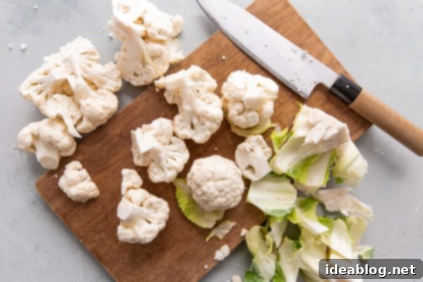 How to Cut Cauliflower - a simple step by step guide on how to cut cauliflower (and how to cut cauliflower florets) for your favorite cauliflower recipes. #abeautifulplate #cooking #guide #cauliflower #howto Cauliflower Florets on Cutting Board after Core Removal