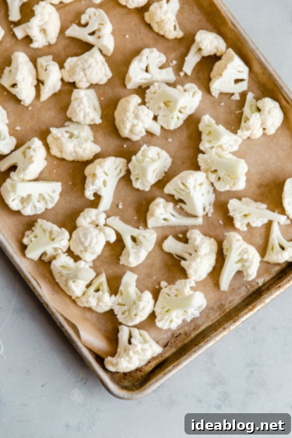 Spicy Vegan Cauliflower Wings 2 Cauliflower Florets on Parchment Lined Half Sheet Pan