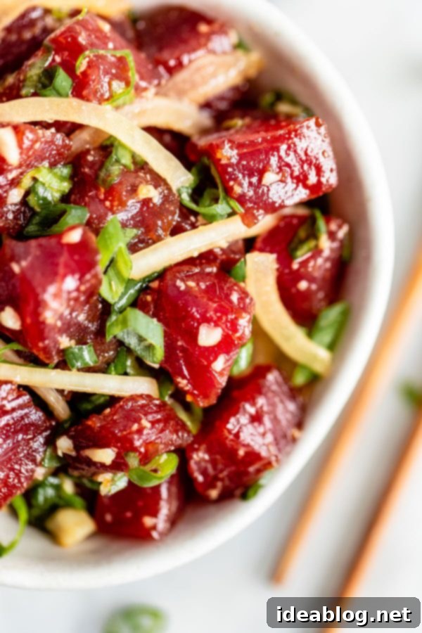 Authentic Shoyu Ahi Poke Recipe - made with sashimi grade ahi tuna, sweet onions, soy sauce, sesame oil, macadamia nuts, and scallions. This incredible dish captures the essence of Hawaii and comes together quickly. Shoyu Ahi Poke, a traditional Hawaiian raw fish dish