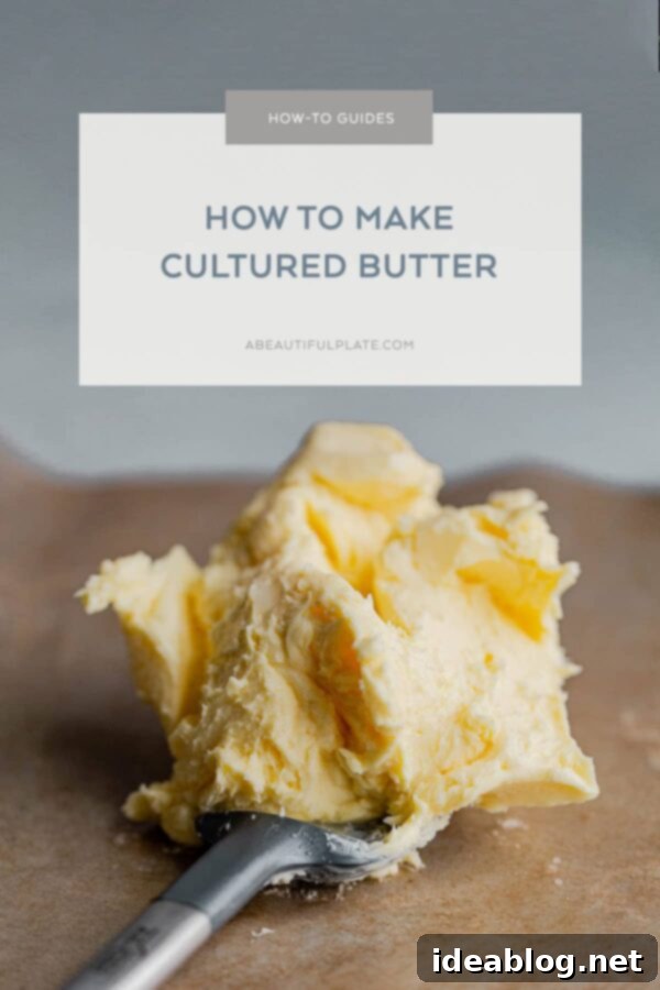 Homemade Cultured Butter: A Step-by-Step Guide to Making Tangy Butter and Real Buttermilk Glorious slab of golden homemade cultured butter on a wooden cutting board, ready for serving or storage.