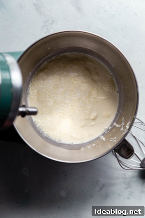 Cultured Cream Ready for Churning - Essential for Homemade Cultured Butter Lidded jar of cultured cream fermenting at room temperature, showing a visibly thickened texture after 24 hours, ready for chilling.