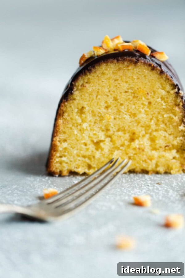 Orange Bundt Cake with Chocolate Glaze - Indulge in a slice of this moist, citrus-infused delight. Fork in front of Slice of Orange Bundt Cake - A fork poised before a slice of the bundt cake, inviting indulgence.