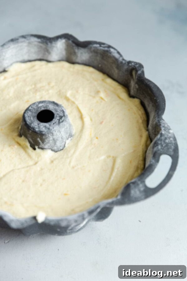 Zesty Orange Bundt with Chocolate Drizzle 2 Orange Cake Batter in Bundt Pan - Close-up of rich orange cake batter being smoothed into a bundt pan.
