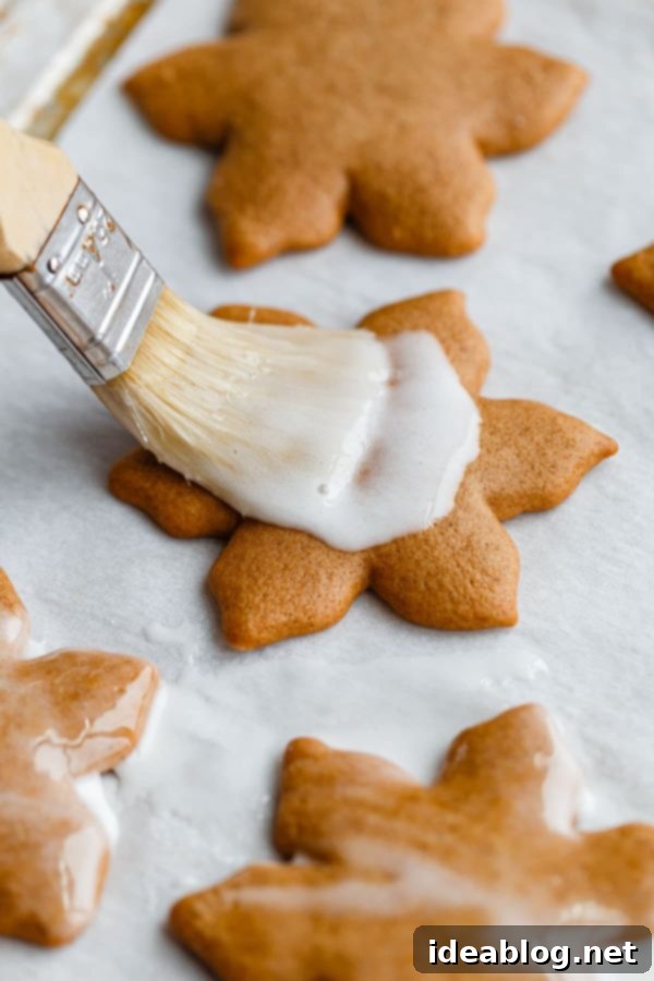 German Lebkuchen Cookies - traditional glazed German Christmas cookies made with warming spices, for a festive treat to enjoy around the holiday season! Brushing Lebkuchen with Lemon Glaze