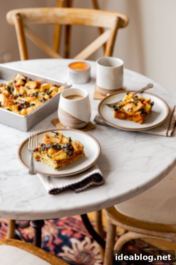 Overnight Breakfast Strata - cheesy, pillowy, and deeply satisfying, this vegetarian breakfast casserole is wonderful any time of year, but particularly ideal for holiday entertaining. #holiday #entertaining #recipe #abeautifulplate #eggs #casserole #chard #cheese #easyrecipes #vegetarian A breakfast spread featuring the Overnight Breakfast Strata, mugs of coffee, and fresh fruit on a rustic table.