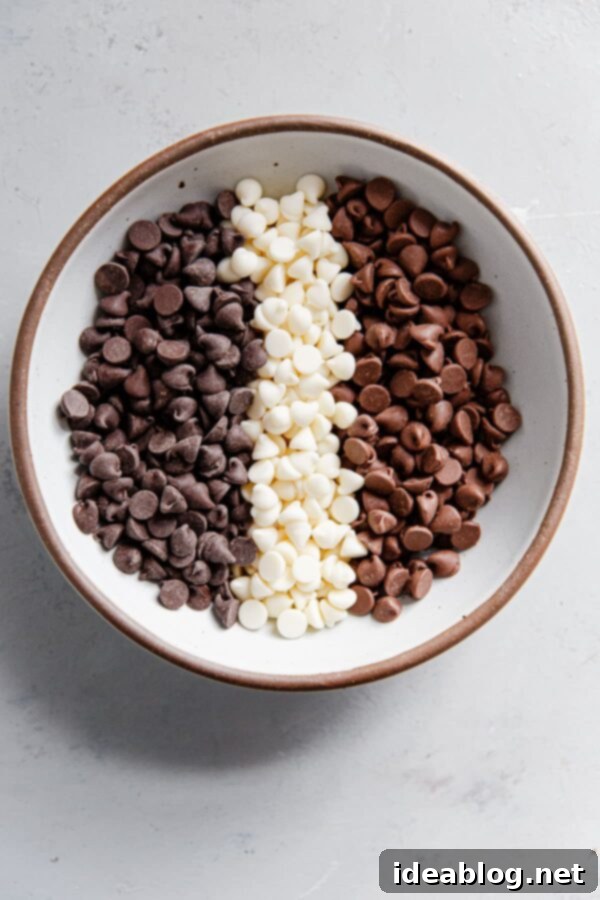 Decadent Triple Chip Chocolate Cookies 4 Three separate bowls containing different types of chocolate chips: white, milk, and semisweet