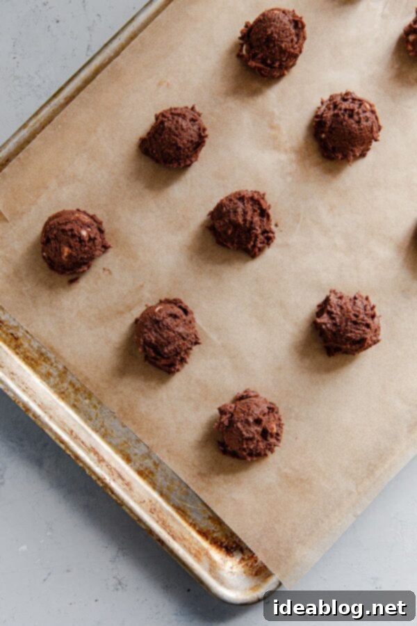Decadent Triple Chip Chocolate Cookies 5 Scoops of triple chocolate cookie dough placed evenly on a parchment-lined baking sheet