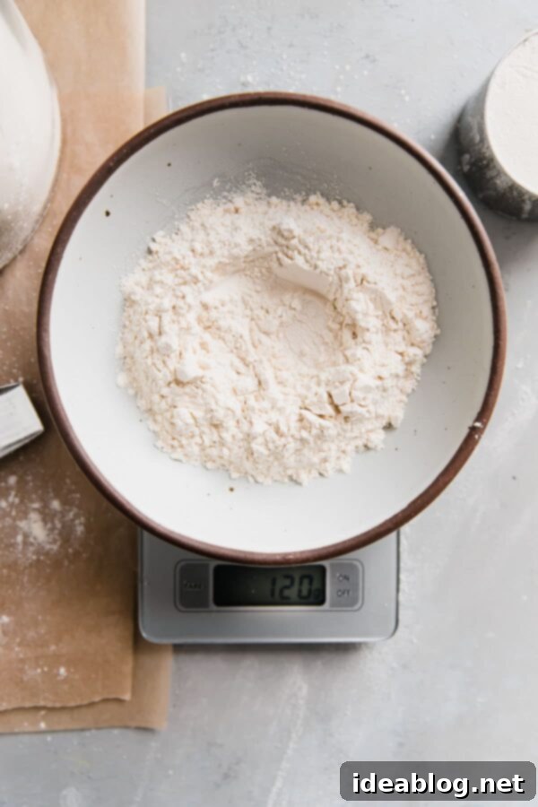 How to Measure Flour Properly - guide on how to measure flour properly - using both volume and metric measurements - as well as how and why the type of method impacts your baked goods. #baking #abeautifulplate #howto #bakingscience Flour in Bowl on Baking Scale